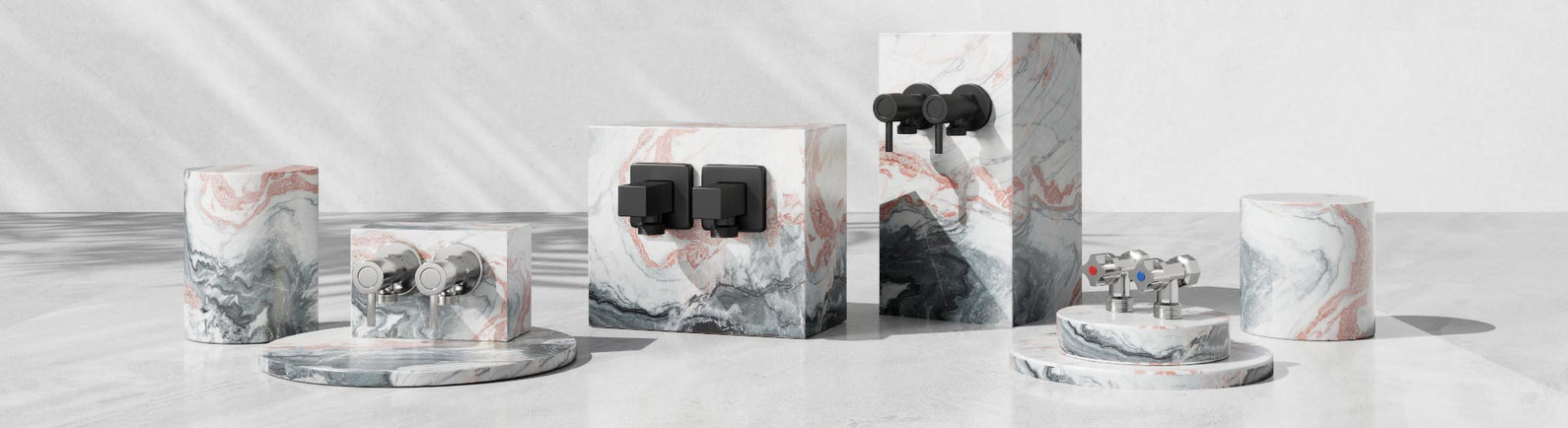 Assorted washing machine taps in chrome and matte black finishes displayed on pink and grey marble stands.