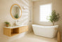 Bathroom with a freestanding bathtub, wall-mounted sink, wooden vanity, and natural light from a window.