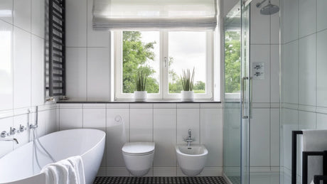 Bright modern bathroom with toilet, bidet, bathtub and glass shower