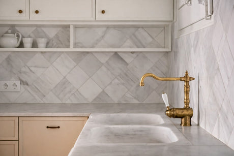 Classic kitchen with marble benchtop, integrated sink, herringbone tile splashback, and brass mixer tap.