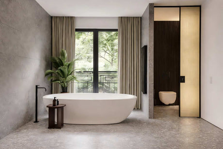 Luxury bathroom with freestanding bathtub, terrazzo flooring, large window, and toilet area.