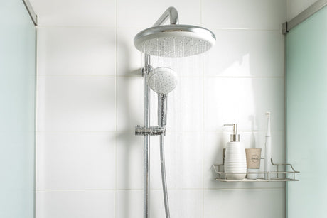 Chrome rainfall shower head running in modern bathroom
