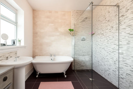 Modern bathroom design with a freestanding bathtub, shower area, and elegant tile walls