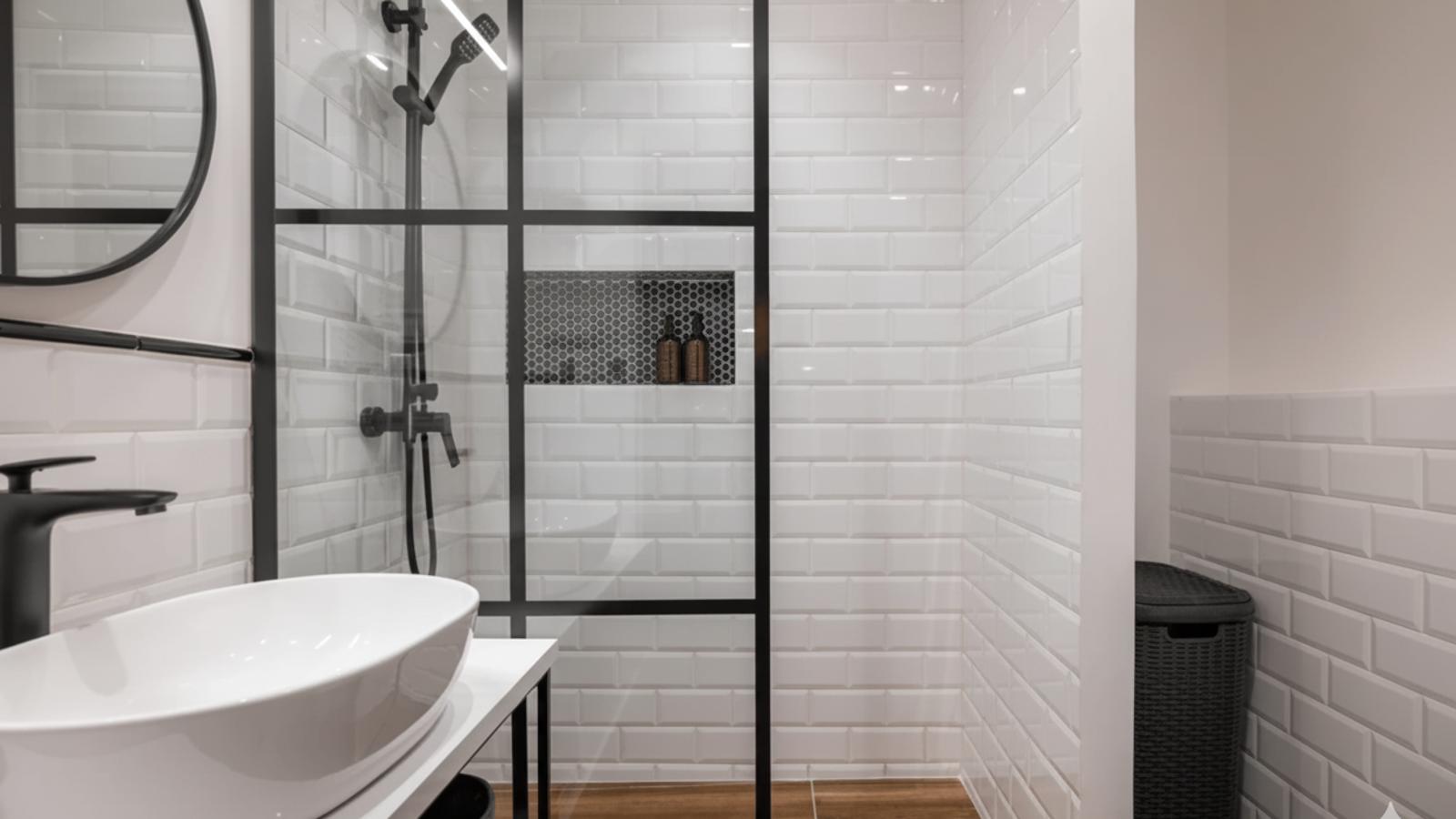 Contemporary bathroom with a white basin, shower, and black accents