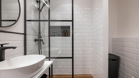 Contemporary bathroom with a white basin, shower, and black accents