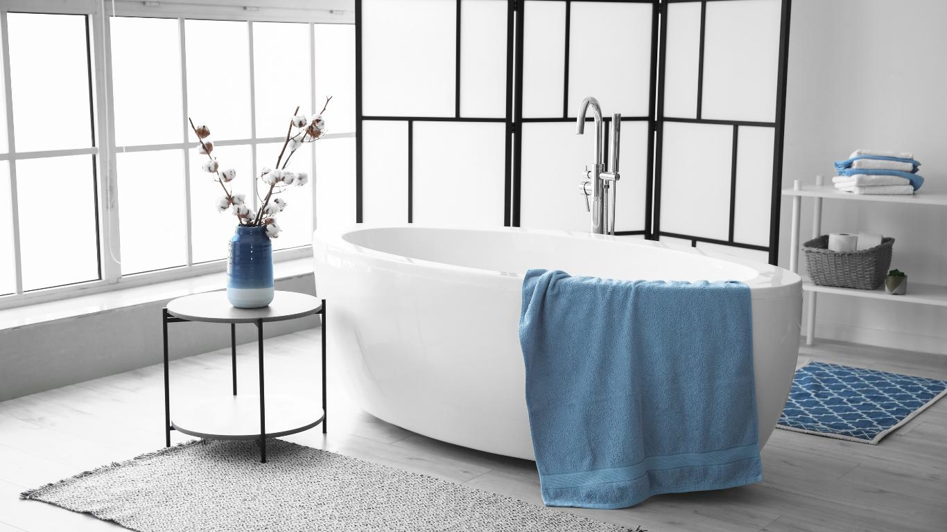 Modern bathroom with freestanding bathtub and blue towel