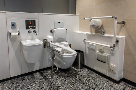 Accessible disability-friendly restroom with hand rails, grab bars and safety aids around toilet and fixtures