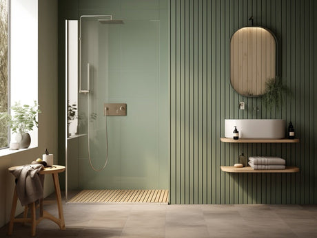 Green bathroom with walk-in shower, floating vanity, vessel sink, and rounded mirror.