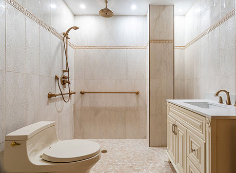 Elegant bathroom interior featuring a walk-in shower with brass fixtures, tiled walls, and a classic vanity with white countertop