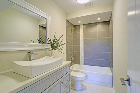 Modern bathtub shower combo with glass screen and wall-mounted shower system.