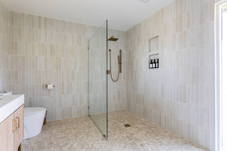Beige hobless shower with walk-in glass panel and tiled floor