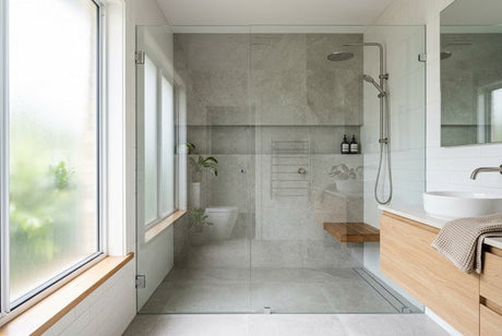 Modern bathroom with frameless glass shower screen, grey stone tiles and timber vanity