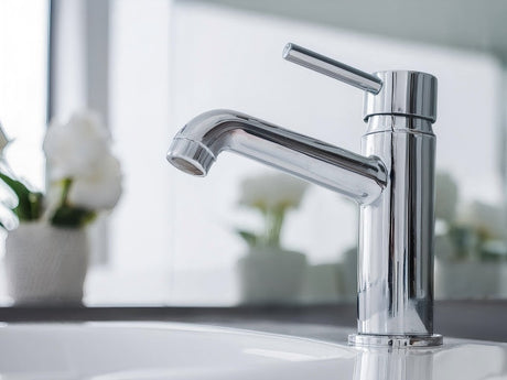 Chrome single lever tapware mixer installed on modern bathroom sink
