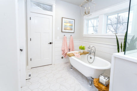 White clawfoot bathtub in a bright farmhouse-style bathroom with natural light