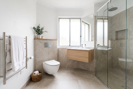 Modern bathroom with wall-hung toilet, timber vanity, glass shower and heated towel rail