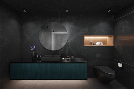 Dark modern bathroom with black tile walls, teal vanity, round mirror, and black toilet
