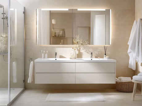 Double vanity bathroom with large LED mirror above sinks demonstrating balanced mirror placement.