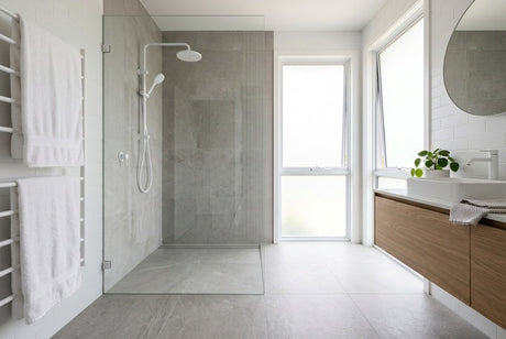 Modern bathroom with frameless hobless shower, grey stone tiles and timber vanity