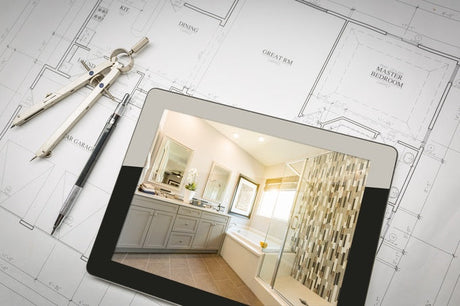 Tablet showing bathroom remodel image on architectural blueprint with compass and drafting pencil
