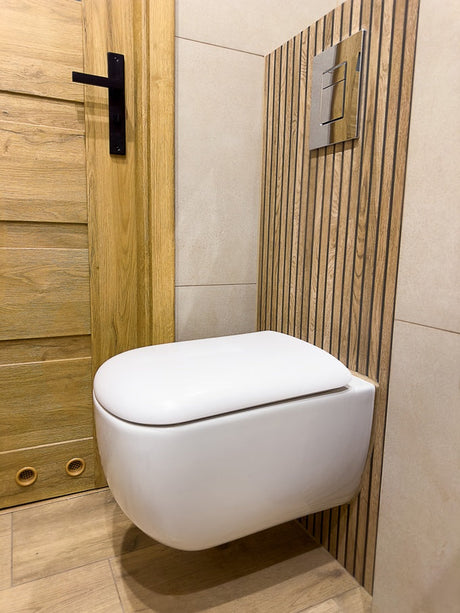 Wall-hung toilet with slatted timber panel and chrome concealed cistern flush plate