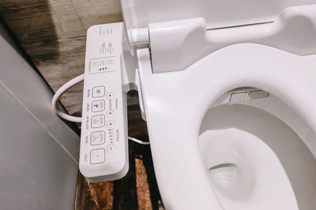 White bidet toilet seat with side control panel showing wash, dry and pressure buttons