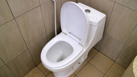 newly installed toilet with open seat in tiled bathroom ready for use