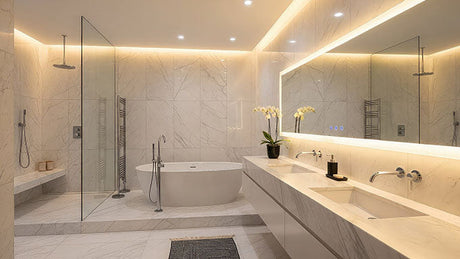 luxury marble bathroom with double vanity, freestanding tub, glass shower, and illuminated mirror