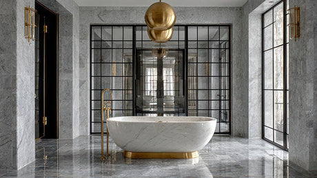 Luxury marble bathroom with white freestanding bath, gold tap and pendant light