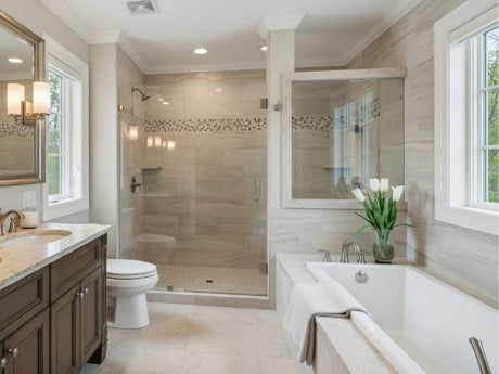 Modern bathroom with bathtub beside glass shower, beige tiles, vanity sink, and large windows.