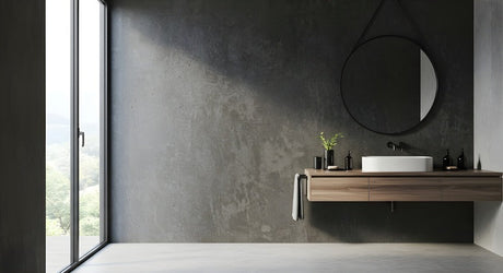 Dark polished concrete bathroom with timber vanity, round mirror and floor-to-ceiling window