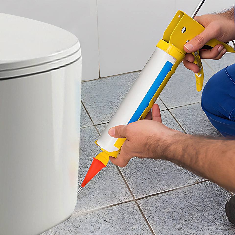 Applying silicone sealant around toilet base