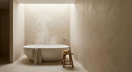 Minimalist bathroom with oval white freestanding bath, steam, and timber stool