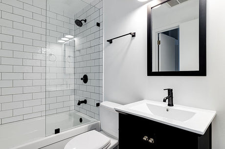 Small modern bathroom with dark vanity and white subway tiles
