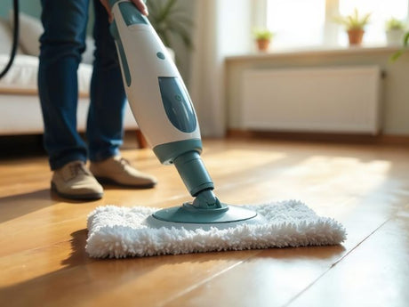 Steam mop cleaning timber hardwood floor surface with microfiber mop head.