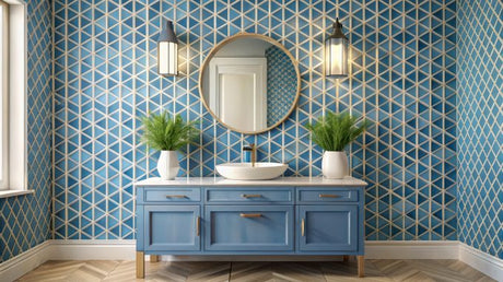 A stylish powder room featuring a round gold-framed mirror, blue vanity with white basin, and geometric patterned wallpaper