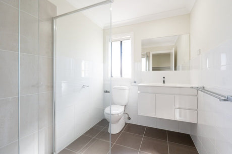 Modern white bathroom with wall-hung vanity, glass shower screen and toilet