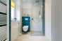 Modern bathroom with wall-hung toilet and glass shower enclosure