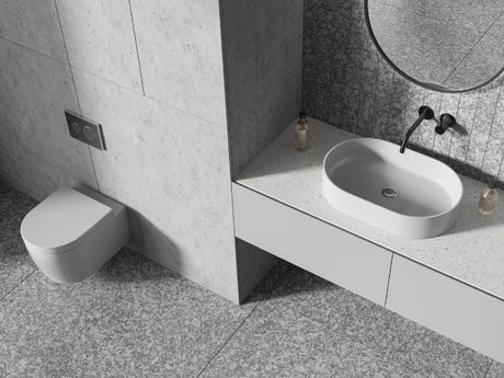 Wall hung toilet beside floating vanity with oval sink in modern concrete bathroom interior