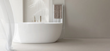 Elegant white freestanding bathtub in a bright modern bathroom setting
