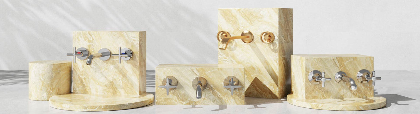 Three-piece wall tap sets with separate hot/cold handles and central spouts in chrome and brushed gold on stone plinths.