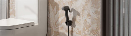 Wall-mounted black bidet spray beside modern toilet