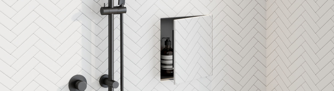 Tile-in recessed wall cabinet with a pivoting door revealing a storage niche.