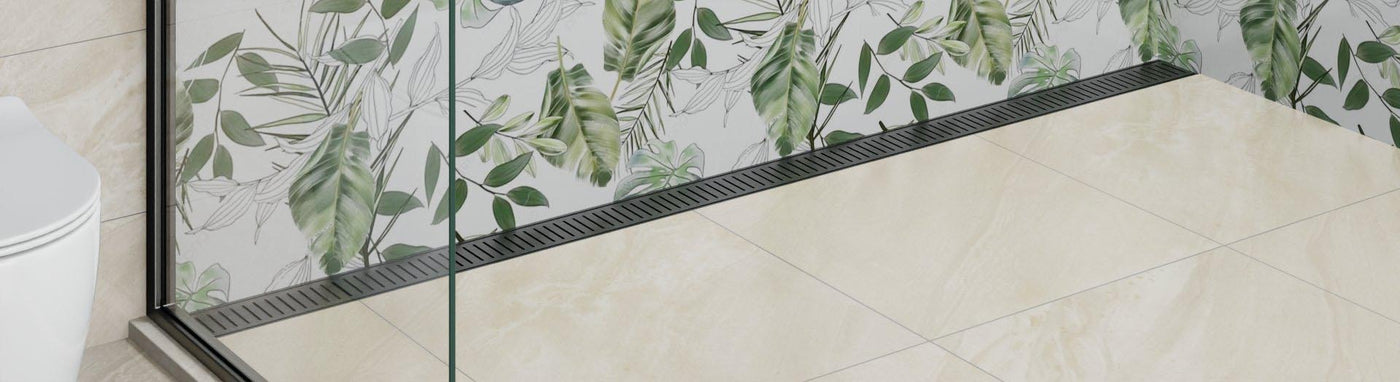 Linear shower grate along glass screen on beige tiled floor