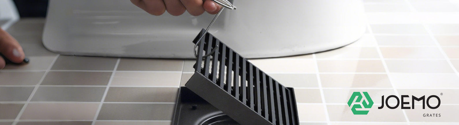 Joemo floor drain grate being installed on tiled bathroom floor