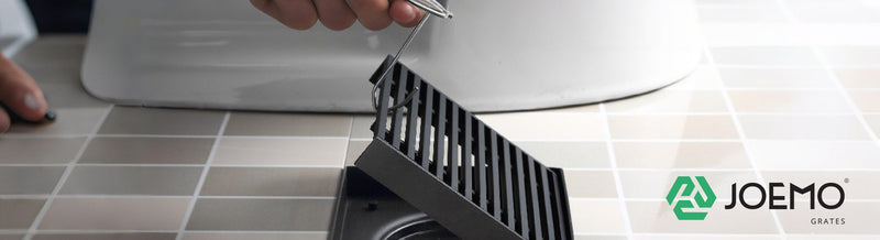 Joemo floor drain grate being installed on tiled bathroom floor