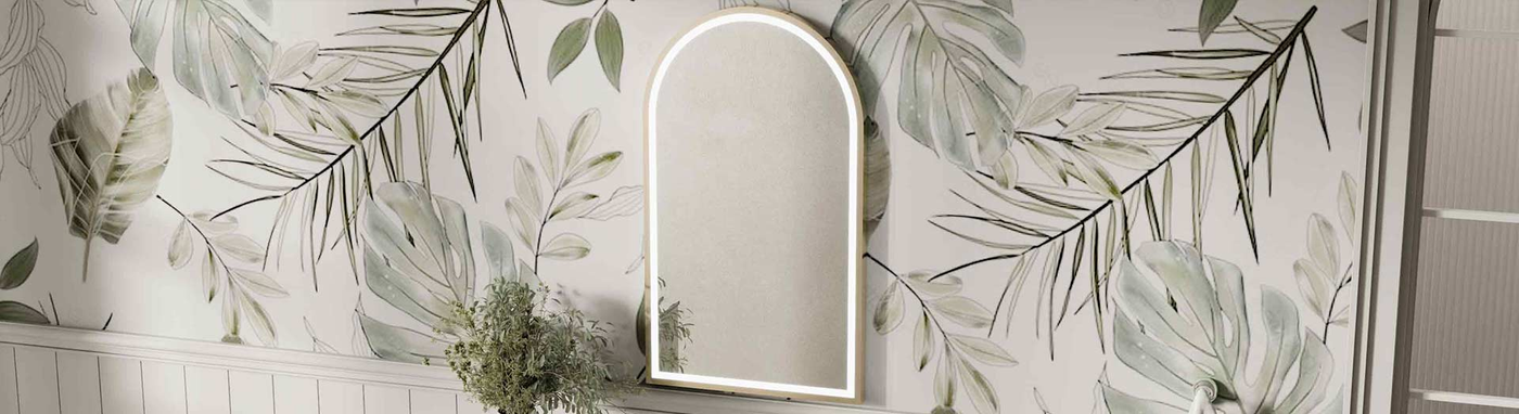 Arched framed LED mirror mounted on a tropical leaf-patterned bathroom wall