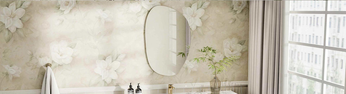 Frameless oval mirror mounted on a floral wallpapered bathroom wall