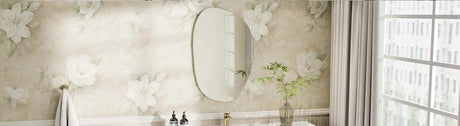 Frameless oval mirror mounted on a floral wallpapered bathroom wall
