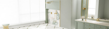 Frameless glass shower screen with brushed gold fittings in a modern bathroom.