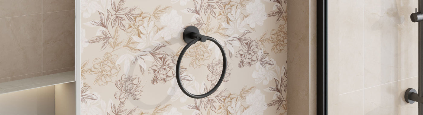 Black circular towel ring on a floral feature wall adjacent to shower glass.
